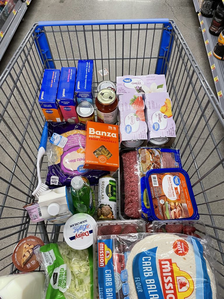 Grocery haul cart full of food items in Walmart