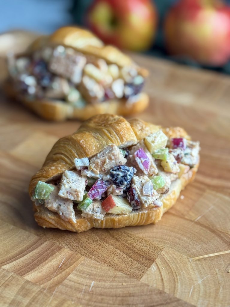 Harvest chicken salad with apples and cranberries on a croissant.