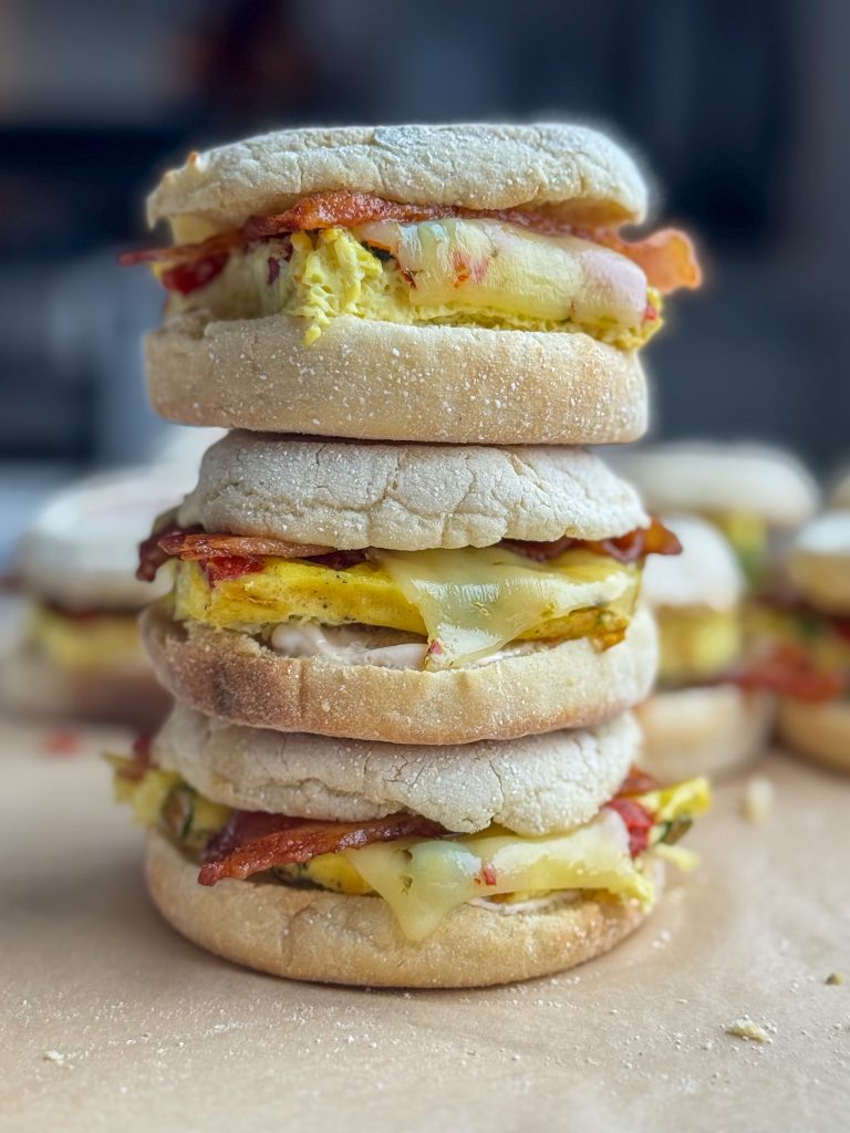 Stack of three southwest bacon and egg breakfast sandwiches.