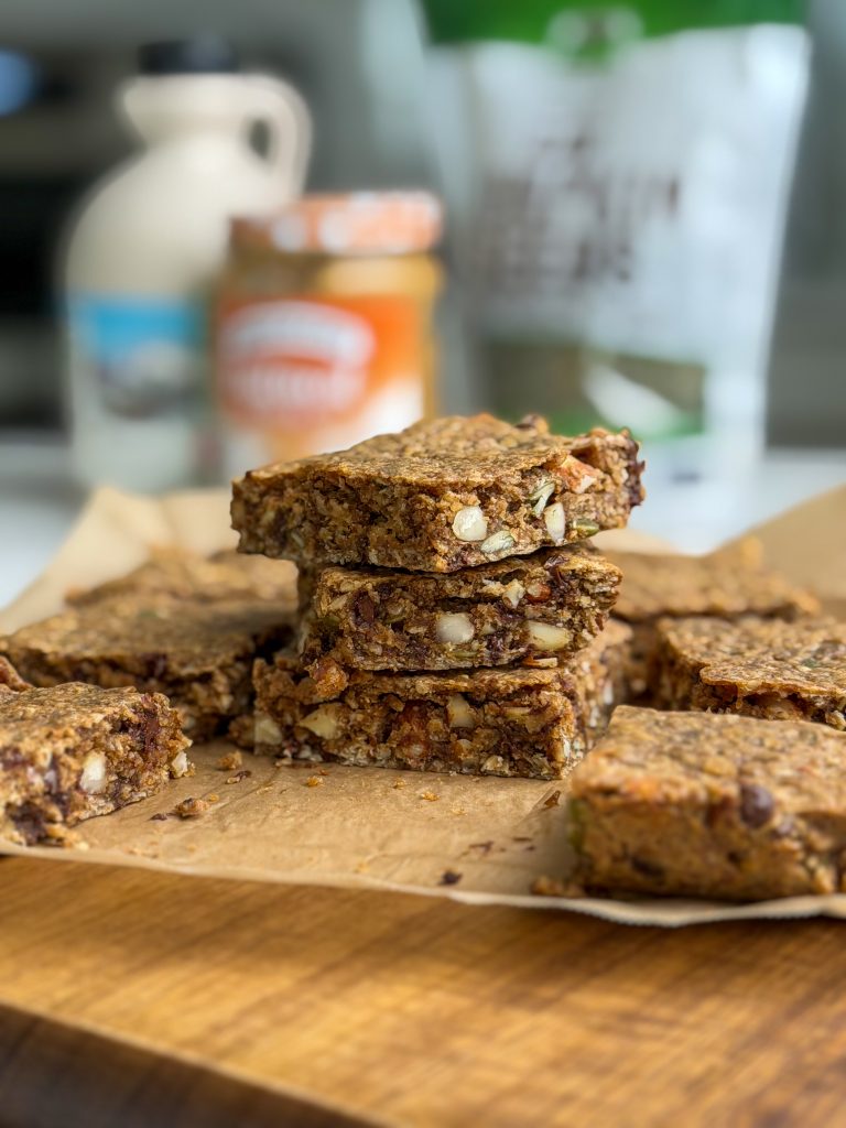 Soft baked energy bars stacked on top of each other on brown parchment paper.