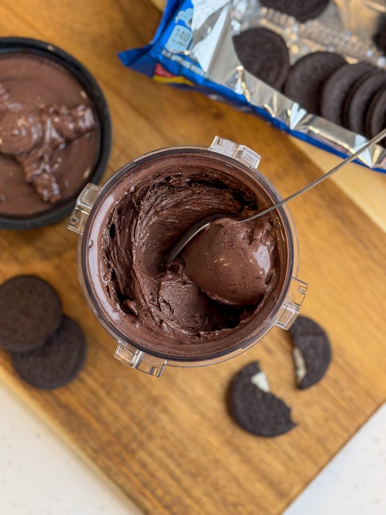 Chocolate Oreo high protein ice cream in a Ninja Creami pint with a spoon.