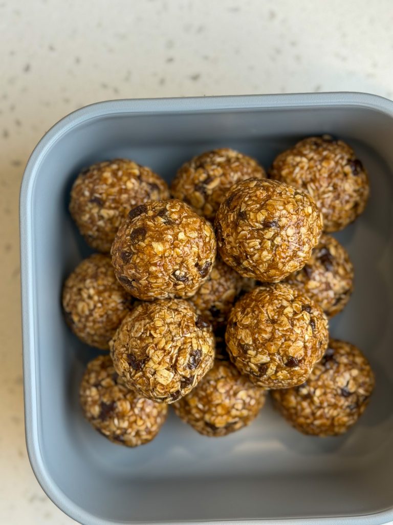 Almond butter chocolate chips energy balls in a gray food container.